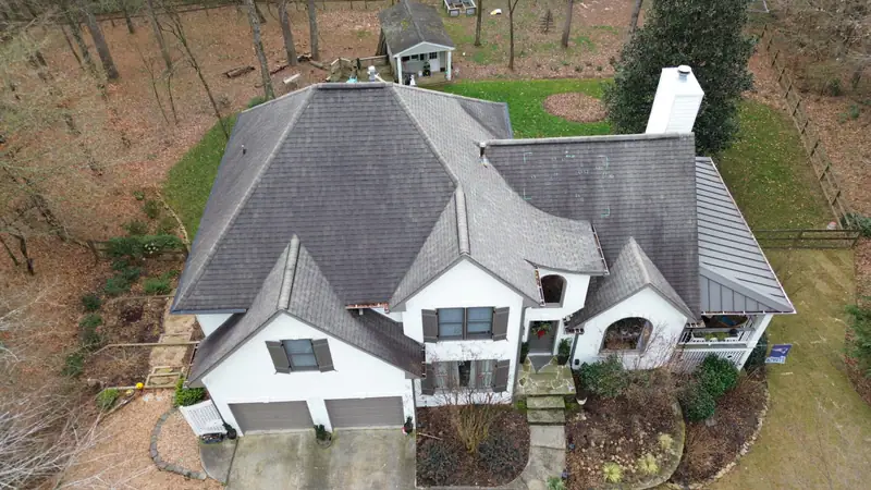 Before: aging gray shingle roof on a large stucco home with multiple gables