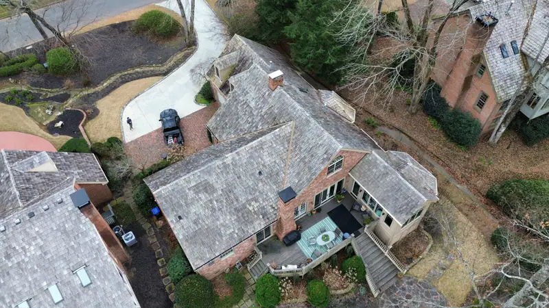 Before: heavily weathered cedar shake roof on a brick home in a wooded North Georgia neighborhood